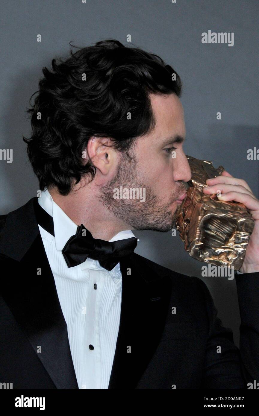 Venezuelan actor Edgar Ramirez kisses his Best Male Newcomer award for the  film "Carlos" during the 36th Cesar Awards ceremony in Paris February 25,  2011. REUTERS/Gonzalo Fuentes (FRANCE - Tags: ENTERTAINMENT Stock