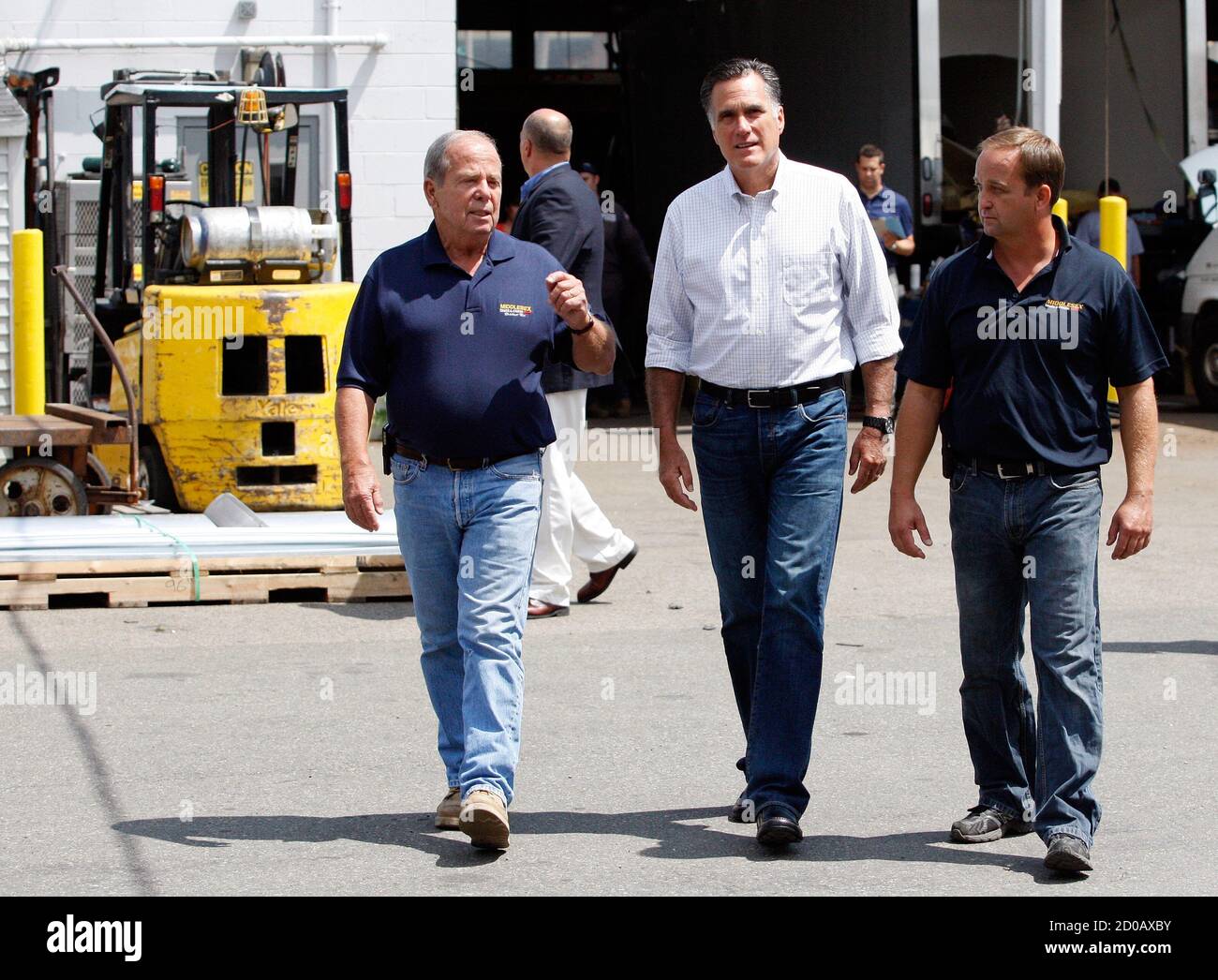 L-R) Middlesex Truck and Coach owner Brian Maloney speaks to .  Republican presidential candidate and former Massachusetts Governor Mitt  Romney as he and his son, Brian Maloney Jr., give him a tour