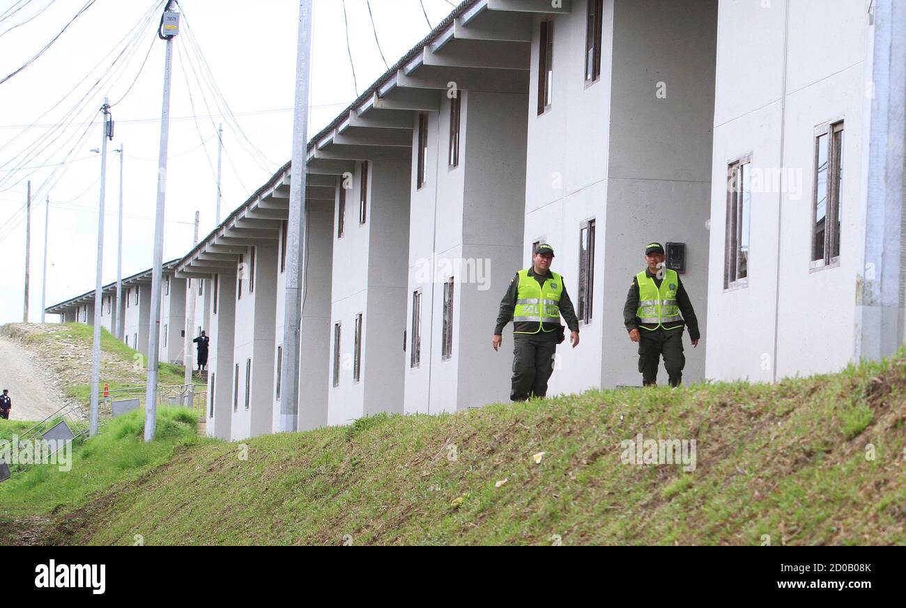 Policemen walk next to 568 new homes built for families living in high-risk  areas in Buenaventura, Valle, February 26, 2013. The homes were constructed  with money seized from drug lord Juan Carlos