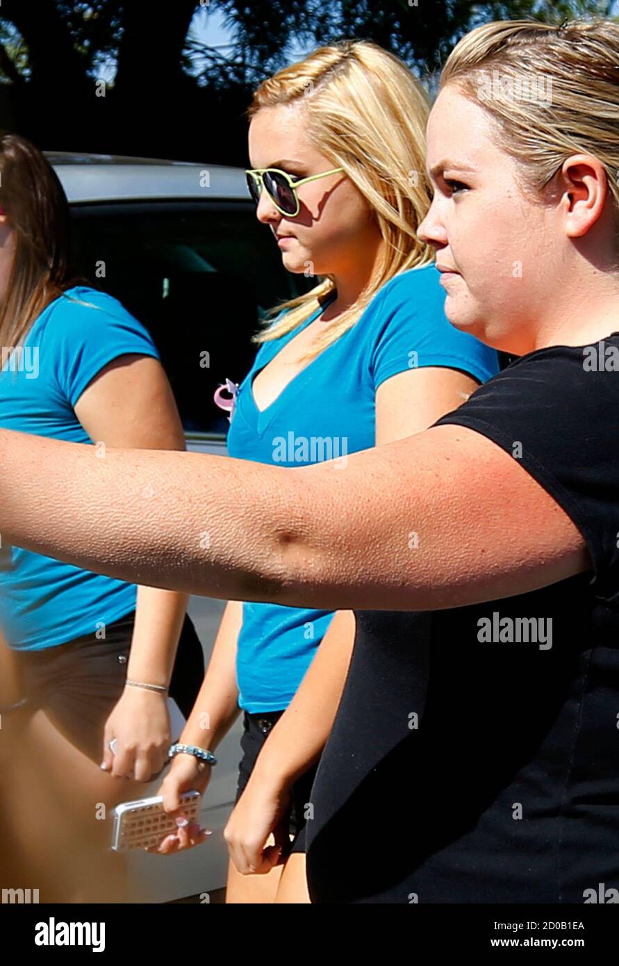 Rescued kidnapping victim Hannah Anderson (C), 16, is escorted into a local restaurant that was holding a raffle and donating profits to help cover the Anderson family funeral costs in Lakeside, California, August 15, 2013. A series of online chat posts attributed to Hannah, but which could not be immediately verified by Reuters, seem to also reveal details about the slayings of Hannah's mother, Christina Anderson, 44, and brother, Ethan, whose remains were found in the ruins of kidnapper James Lee DiMaggio's house at the outset of her disappearance. Hannah posted that they burned to death in  Stock Photo