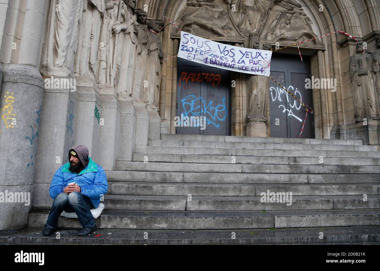 A beggar sits at the entrance of the "Gesu Squat," an abandoned convent, in  Brussels November 4, 2013. Some 200 squatters, including 90 children, were  evicted early in the morning after a