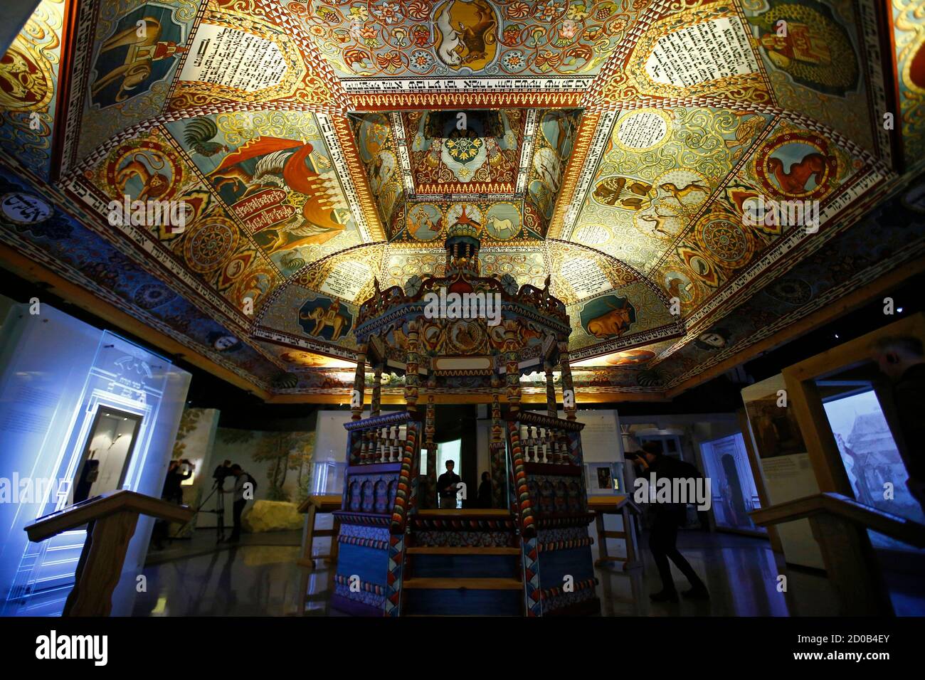 Visitors stand under the 'Celestial Canopy', a reconstructed painted ceiling of a synagogue that once stood in Gwozdziec (present-day Ukraine), at the POLIN Museum of the History of Polish Jews in Warsaw October 21, 2014, one week before the official opening of the core exhibition. Poland, the country on whose soil Nazi Germany carried out the darkest acts of the Holocaust, is starting to re-connect with its other role in Jewish history, as a home for 1,000 years to one of the world's biggest Jewish communities. The country will take a step in that direction next week with the opening of the m Stock Photo