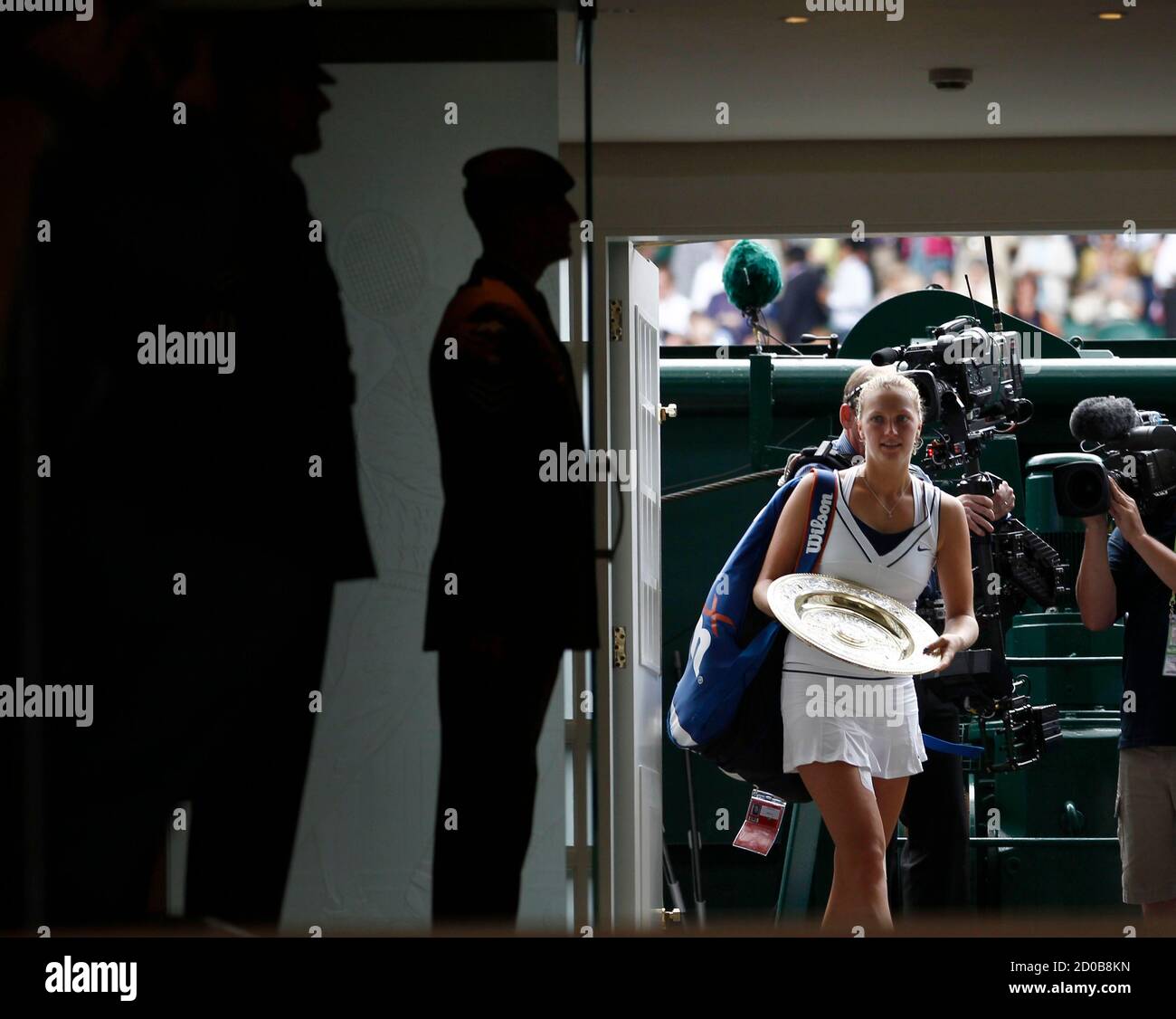 Petra Kvitova of the Czech Republic holding the winners trophy walks off Centre Court and into the clubhouse after defeating Maria Sharapova of Russia in the women's singles final at the Wimbledon tennis championships in London July 2, 2011.    REUTERS/Eddie Keogh (BRITAIN  - Tags: SPORT TENNIS IMAGE OF THE DAY TOP PICTURE) Stock Photo