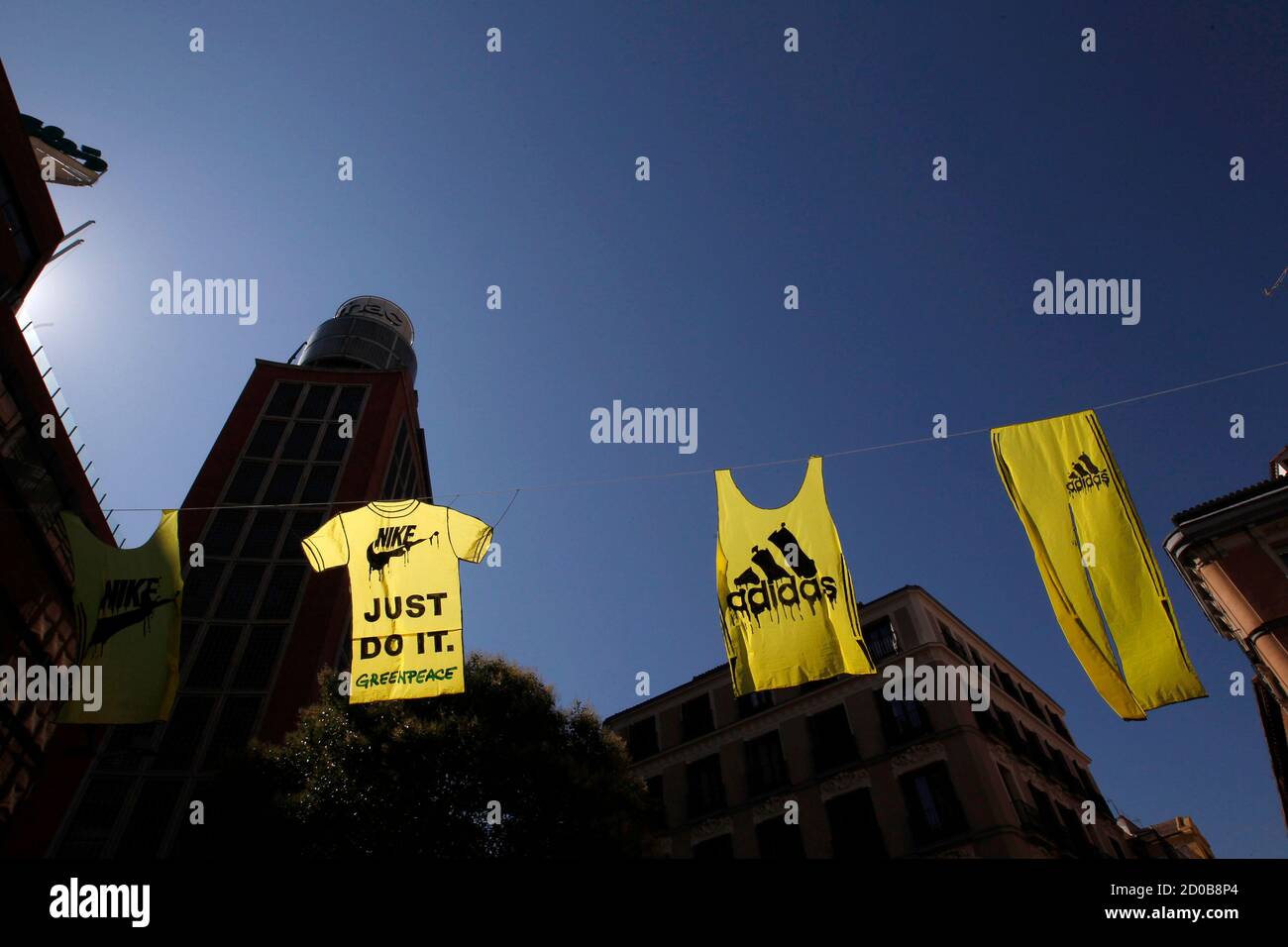 Banners representing clothes of Nike and Adidas hang from a line during a  protest in central Madrid July 14, 2011. Greenpeace staged the protest to  denounce the polluting of the Yangtze and