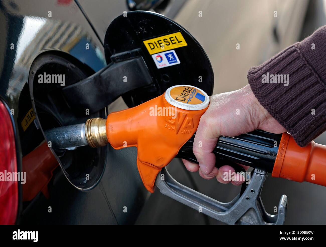 A customer fills-up his car with diesel at a gas station in Nice March 4,  2013. France is considering creating a car scrappage scheme for owners of  older diesel vehicles as the