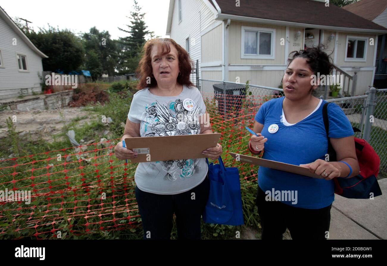 Naomi Flores (L) and Vanita Singh, members of Taking Action por Nuestros Ninos, canvas a street and record the address and condition of a vacant lot where a house was demolished but the debris was not removed, in Southwest Detroit, Michigan August 21, 2013. Picture taken August 21, 2013. REUTERS/Rebecca Cook (UNITED STATES - Tags: BUSINESS REAL ESTATE) Stock Photo