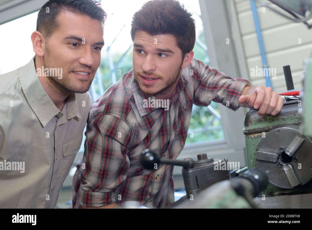 two male workers looking at machinery in factory Stock Photo - Alamy