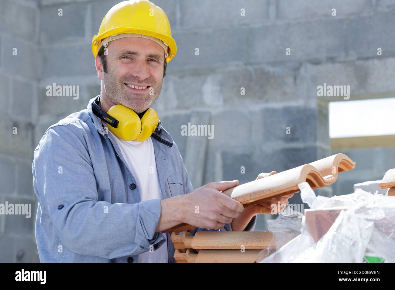 portrait of a male worker holding a clay tile Stock Photo - Alamy