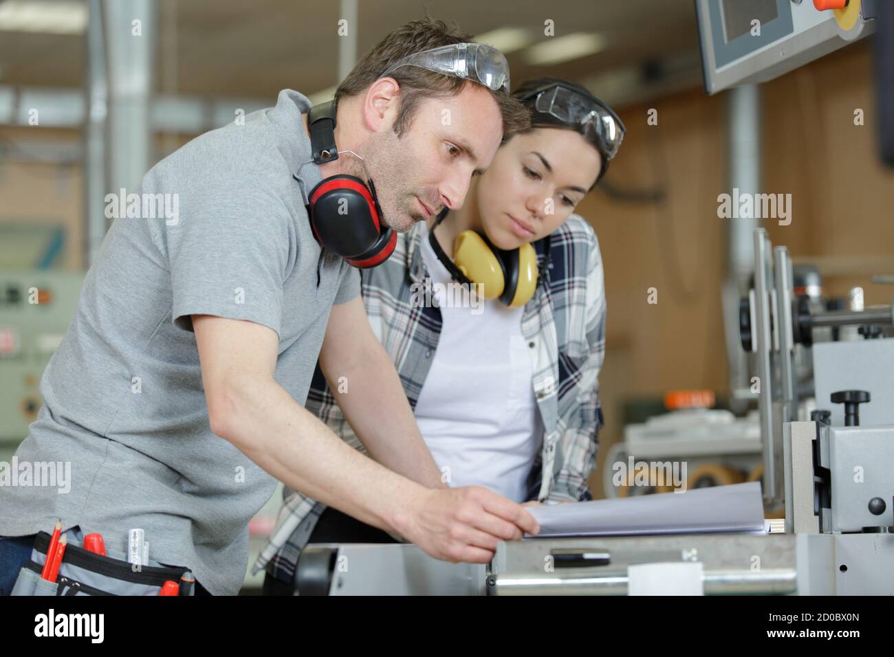 portrait of apprentice working with engineer on cnc machine Stock Photo