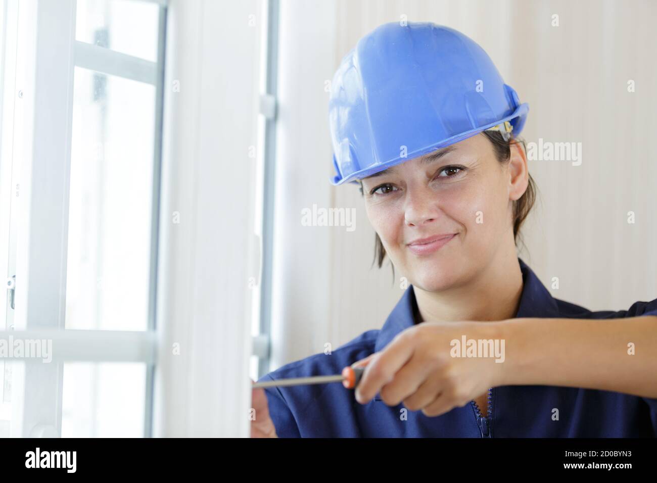 woman installing blinds with screwdriver Stock Photo
