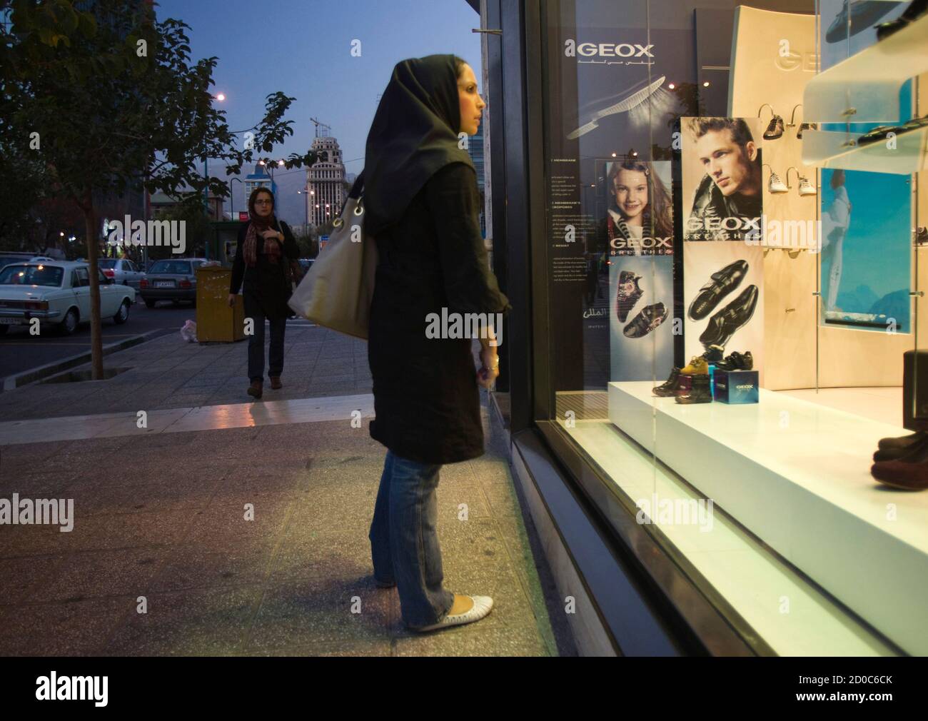 An Iranian woman looks in the window of a Geox store in northern Tehran  October 24, 2010. While ordinary Iranians struggle to survive international  sanctions and deepening economic uncertainty, the gap has