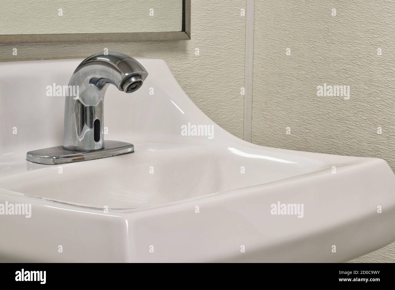 Touchless automated bathroom faucet and sink, angled view showing