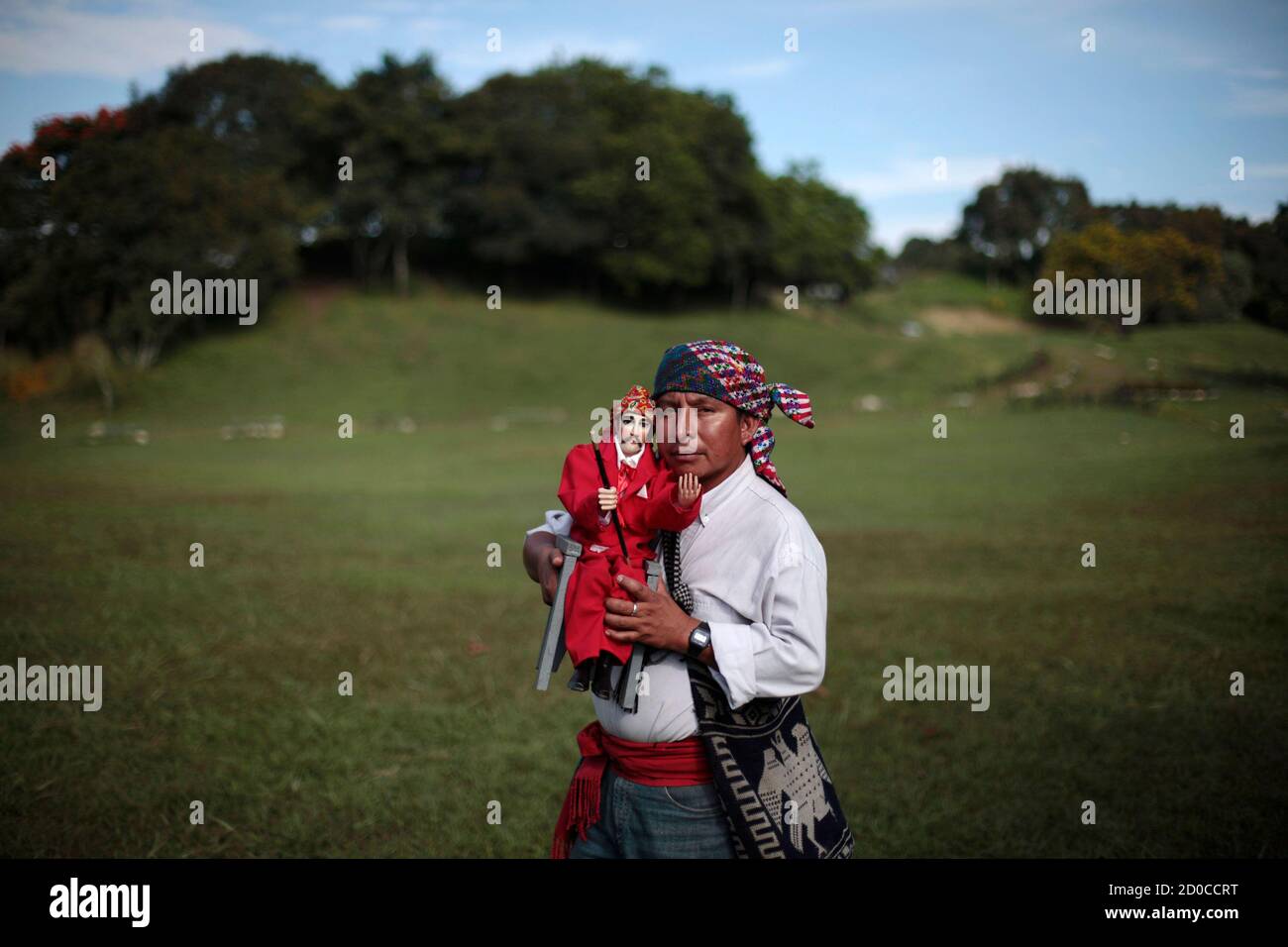 A Mayan spiritual guide Alfredo Salomon carries a doll of San Simon while  reenacting a pre-hispanic mass in honor of San Simon in Kaminal Juyu, in  Guatemala City, October 28, 2012. San