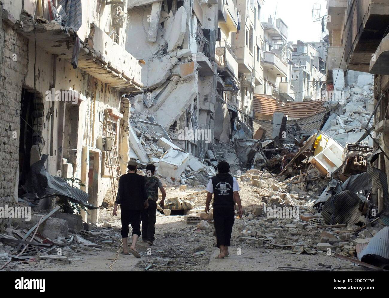 Free Syrian Army fighters walk on rubble of damaged buildings in Juret al-Shayah in Homs November 1, 2012. Picture taken November 1, 2012.  REUTERS/Yazan Homsy (SYRIA - Tags: CONFLICT POLITICS) Stock Photo