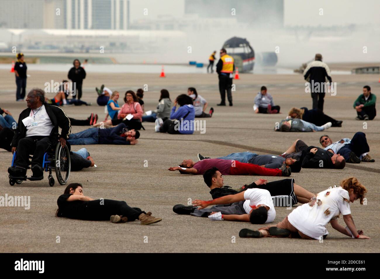 Actors portraying flight crash victims wait to be treated by emergency personnel during the full-scale, LAX Air Exercise aircraft disaster simulation training drill at Los Angeles International Airport (LAX), in Los Angeles, California April 24, 2013. The LAX AirEx is a two-hour long simulated aircraft disaster with over 100 volunteers in moulage, role-playing as accident victims and is designed to test LAX's Emergency Response Plan, as required by the Federal Aviation Administration (FAA) at least once every three years to evaluate the operational capability and readiness of LAX's emergency m Stock Photo