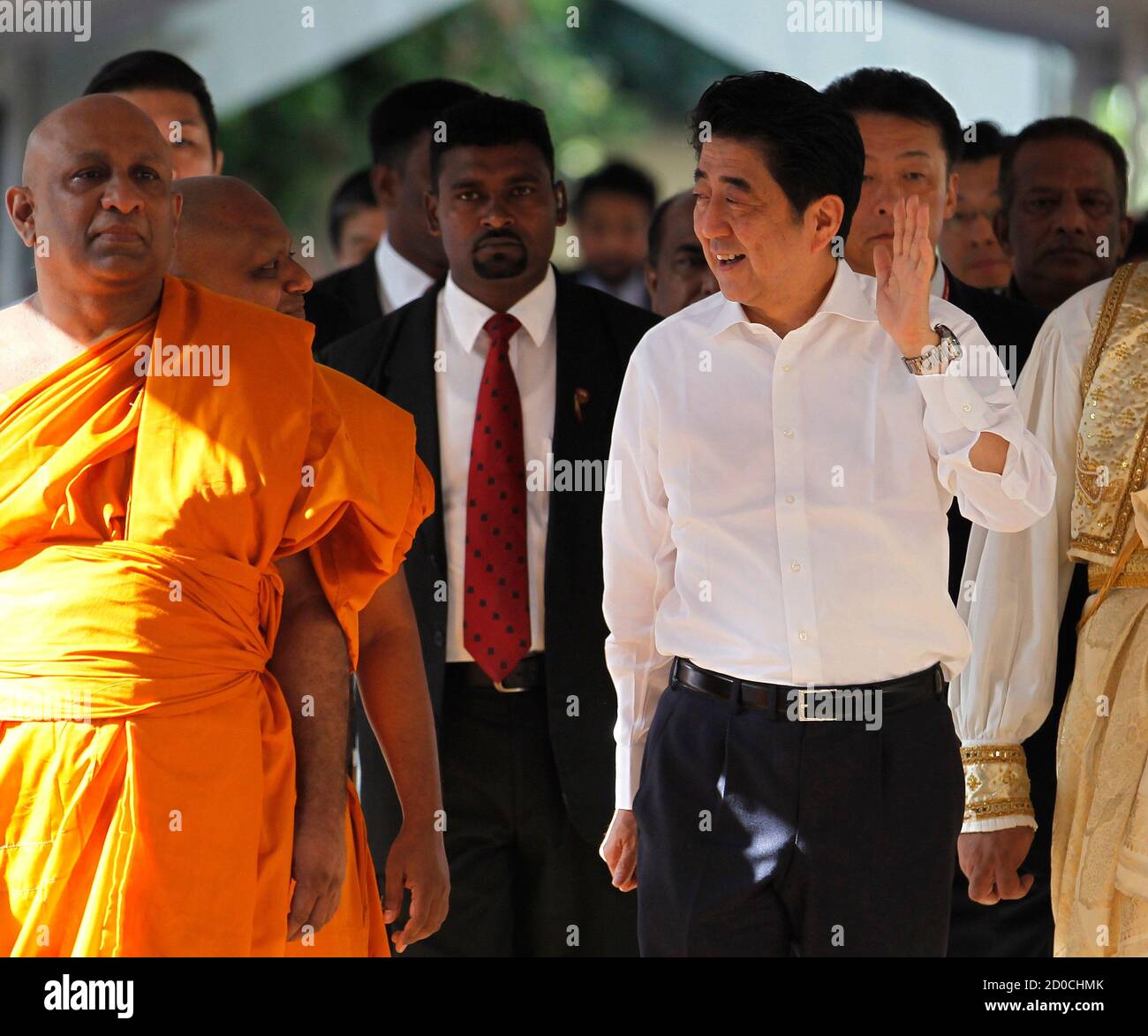 Japan's Prime Minister Shinzo Abe (R) walks as he gestures at devotees during his visit at Kelaniya Buddhist Temple in Kelaniya September 8, 2014. Abe on Sunday became the first Japanese prime minister to visit Sri Lanka in 24 years, on the second leg of a South Asian tour. REUTERS/Dinuka Liyanawatte (SRI LANKA - Tags: POLITICS RELIGION) Stock Photo