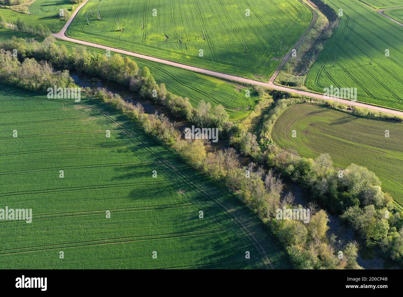 Beautiful spring time farmland landscape with river and gravel road, aerial view Stock Photo