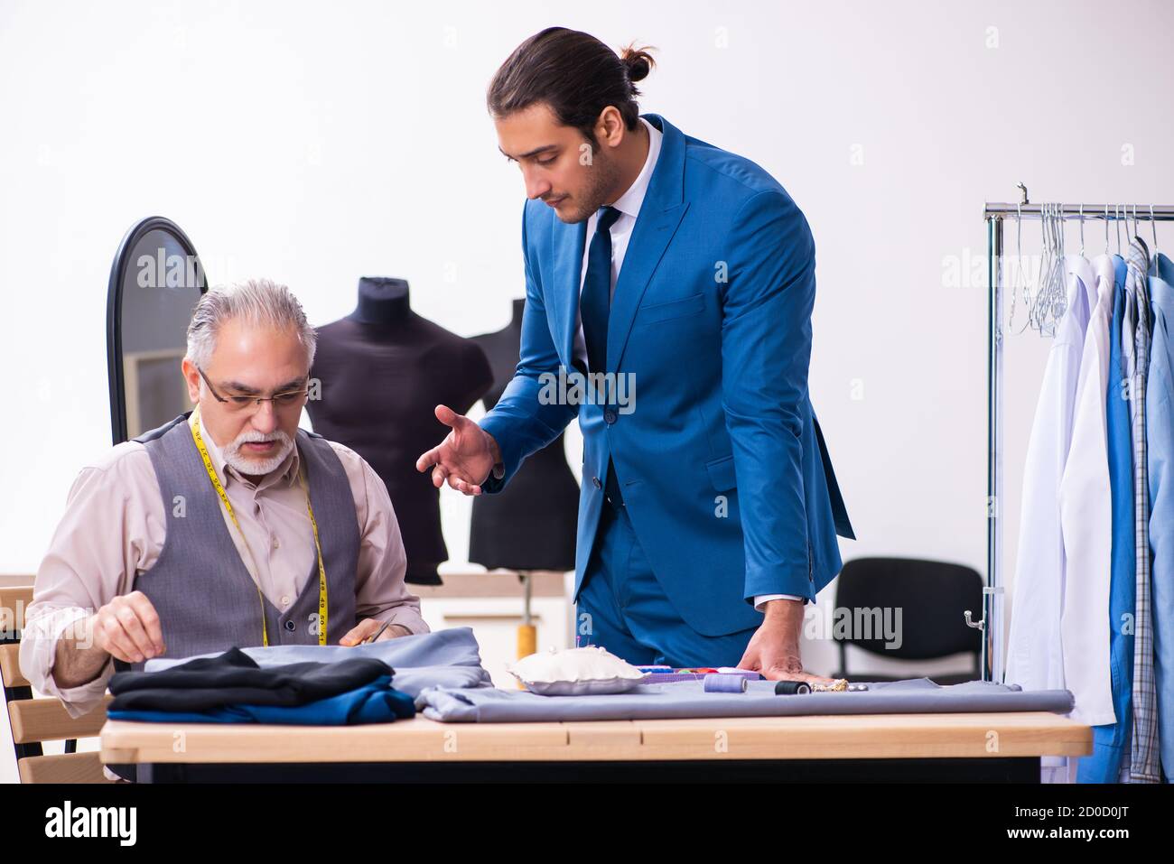 Young businessman visiting old tailor Stock Photo