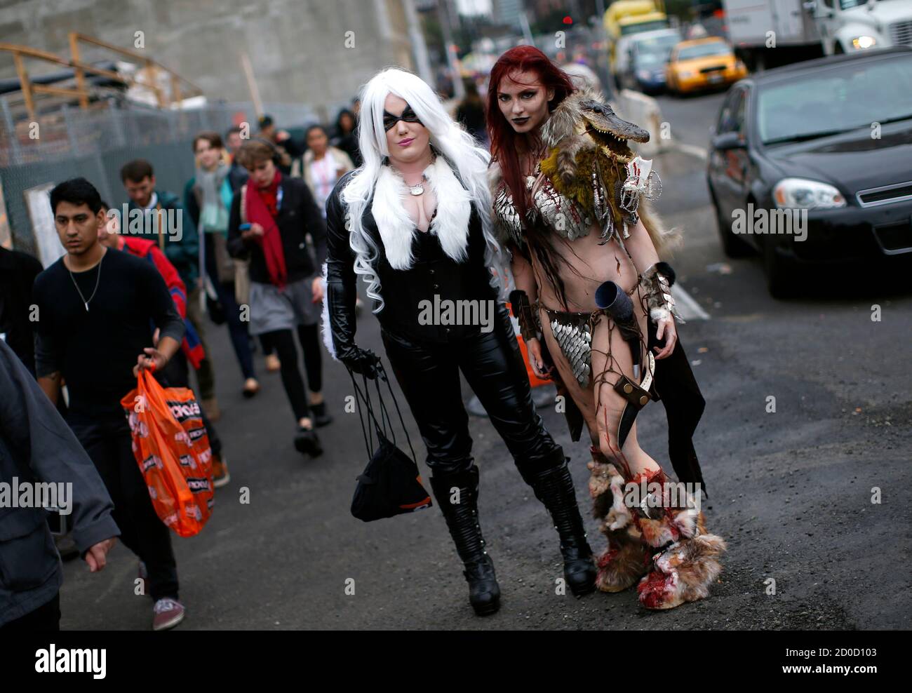 Nicci Fette (R), dressed as comic book character Red Sonja, and Courtney  Rose (L), dressed as Red Cat, pose for a photograph at New York's Comic-Con  convention October 11, 2013. The event