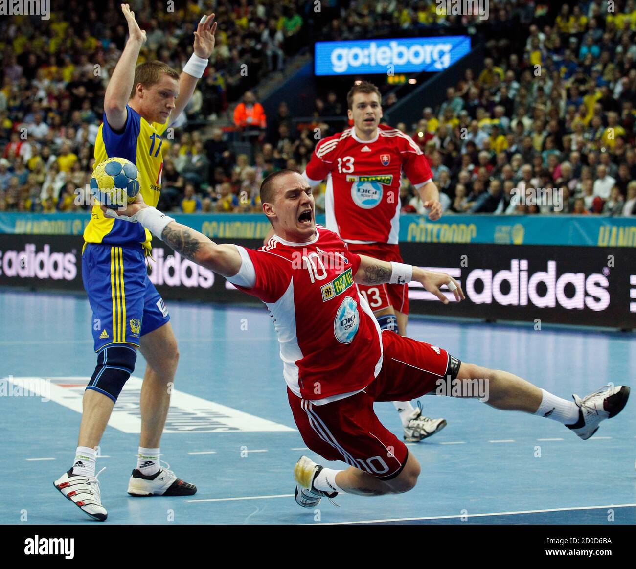 Slovakia's Michal Kopco (C) shoots on the goal next to Sweden's Oscar  Carlen (L) during their game at the Men's Handball World Championship in  Gothenburg January 15, 2011. REUTERS/Umit Bektas (SWEDEN -