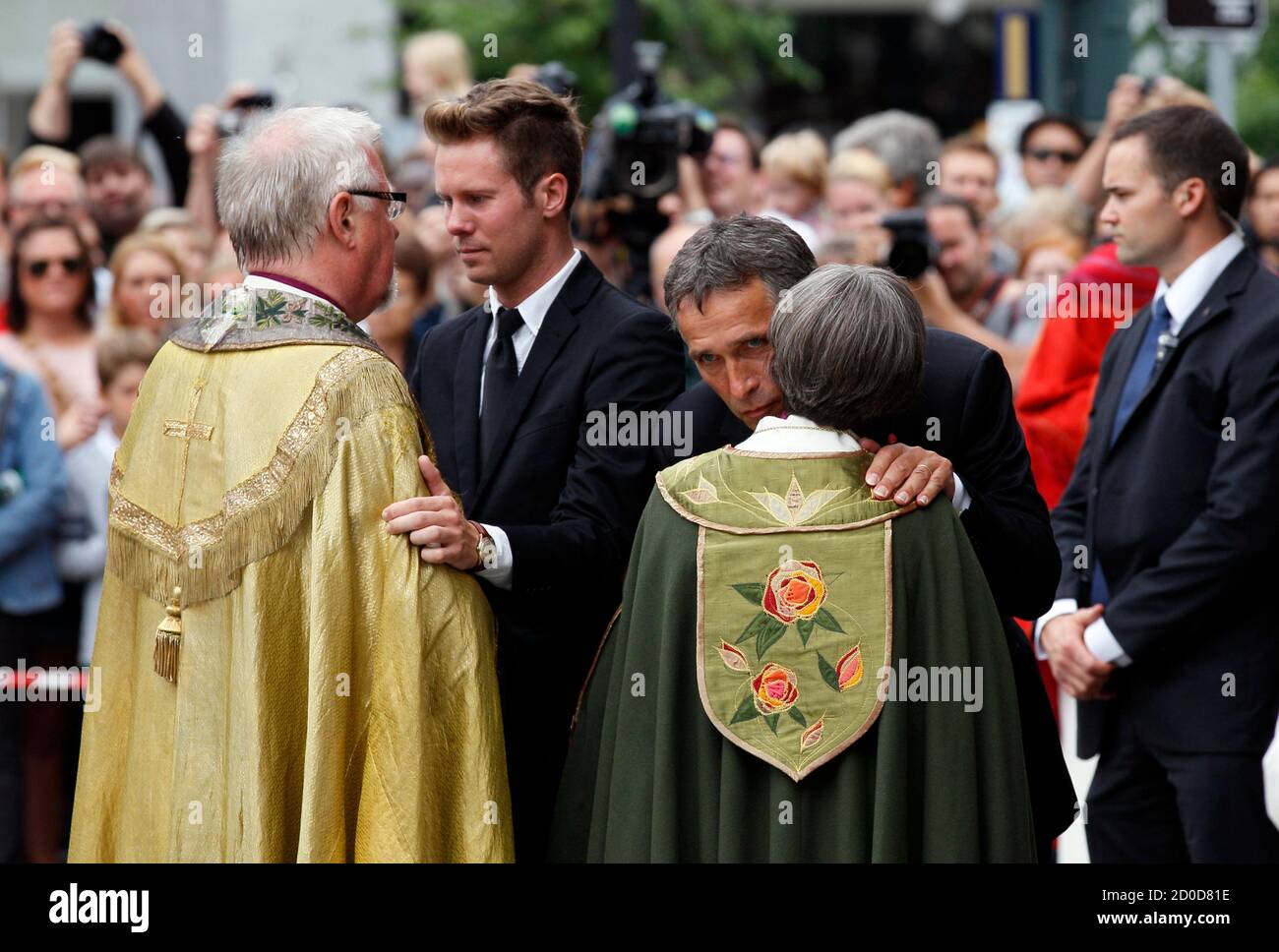 Norwegian Prime Minister Jens Stoltenberg (R) and Eskil Pedersen (2nd L), the leader of the youth wing of ruling Labour Party, are comforted by priests after a memorial service at a cathedral in Oslo, July 24, 2011. A right-wing zealot who admitted to bomb and gun attacks in Norway that killed 92 people on Friday claims he acted alone, Norway's police said on Sunday. REUTERS/Wolfgang Rattay (NORWAY - Tags: CIVIL UNREST CRIME LAW POLITICS RELIGION) Stock Photo