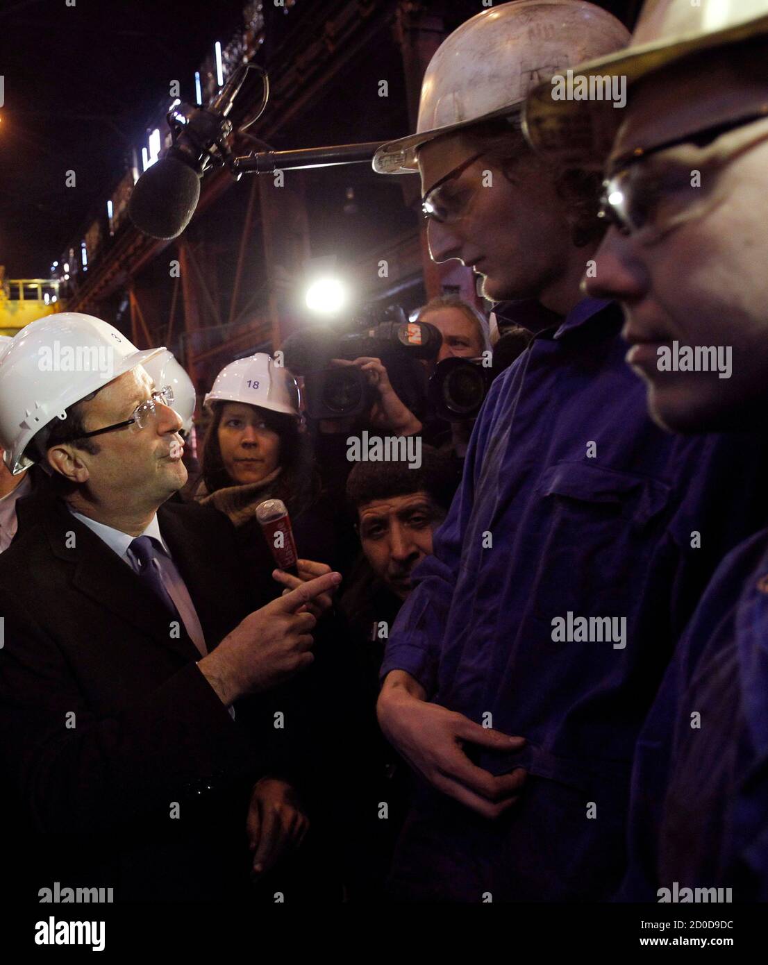 Francois Hollande (L), Socialist Party candidate for the 2012 French presidential election, speaks with steel workers as he visits Akers, a steel factory, in Thionville, eastern France, January 17, 2012.    REUTERS/Christophe Ena/Pool   (FRANCE - Tags: POLITICS BUSINESS EMPLOYMENT) Stock Photo