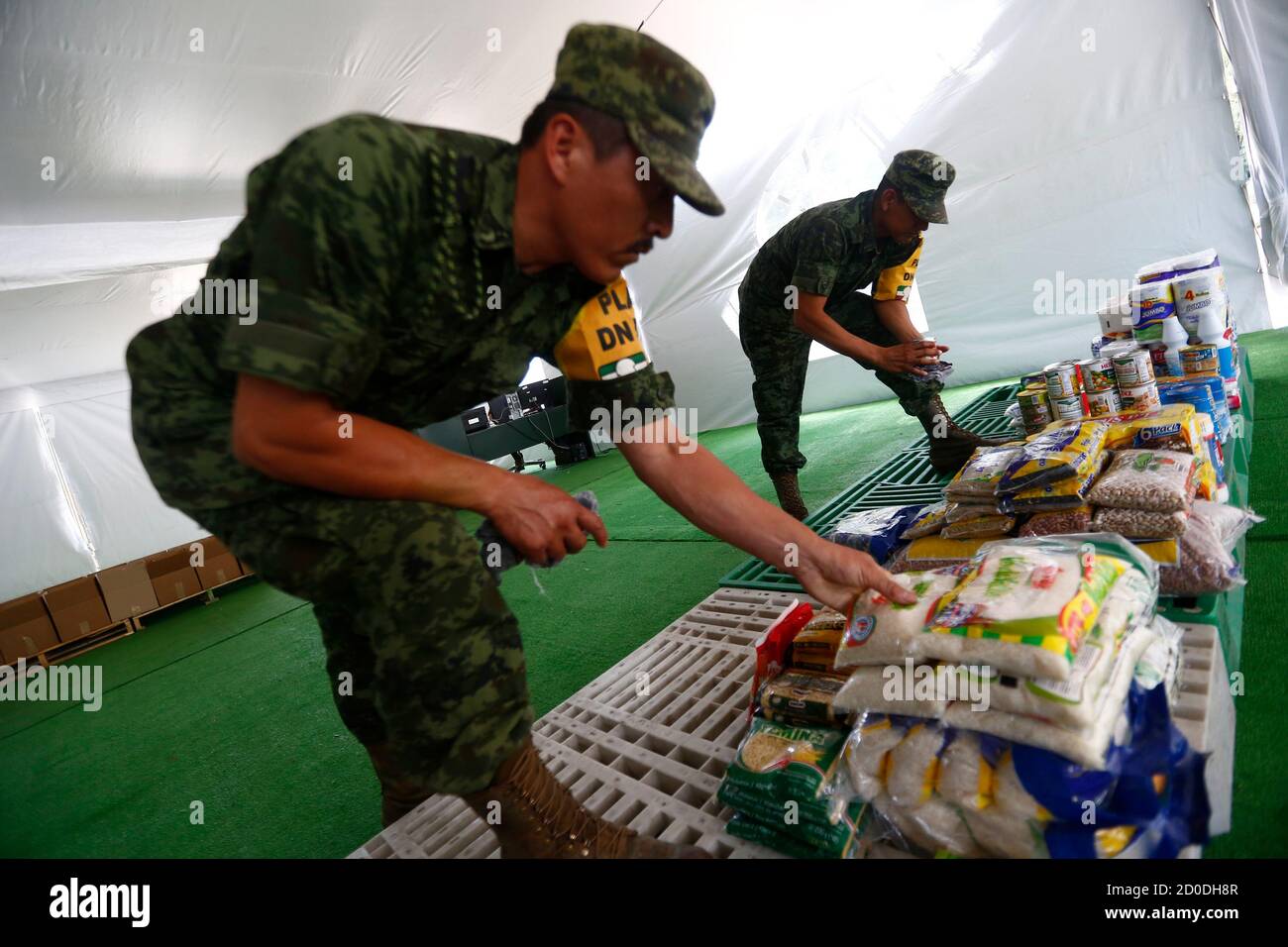 Soldiers sort food donated by Mexican citizens to help people affected by Hurricane Odile in Mexico City September 18, 2014. Thousands of tourists were stranded in the storm-battered Mexican Pacific resort of Los Cabos on Thursday, with water in short supply and looted stores sitting empty as a new hurricane threatened to buffet the popular tourist hub. Odile churned into the southern tip of the Baja California peninsula on September 14, 2014 as a Category 3 hurricane, wreaking havoc on a scenic area popular with U.S sun seekers that has rarely witnessed such devastation. REUTERS/Edgard Garrid Stock Photo