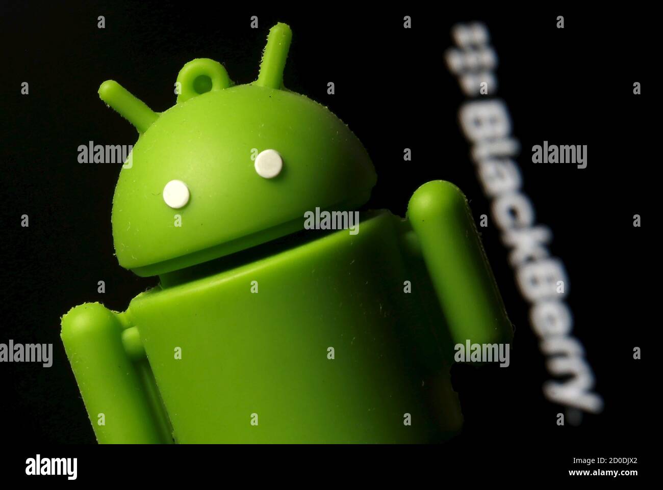 An Android mascot is seen in front of a logo of Blackberry in this photo illustration taken in Zenica, Bosnia and Herzegovina, June 12, 2015. BlackBerry is considering equipping an upcoming smartphone with Google Inc.'s Android software for the first time, an acknowledgement that its revamped line of devices has failed to win mass appeal, according to four sources familiar with the matter. The move would be an about-face for the Waterloo, Ontario-based company, which had shunned Android in a bet that its BlackBerry 10 line of phones would be able to claw back market share lost to Apple's iPhon Stock Photo