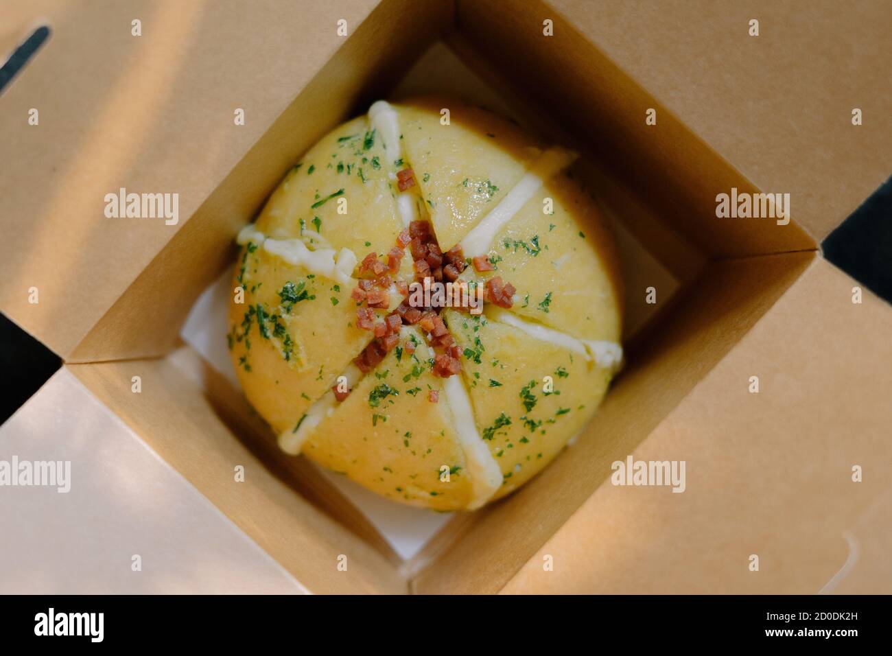 Closeup of Korean garlic cheese bread inside a brown paper box Stock Photo