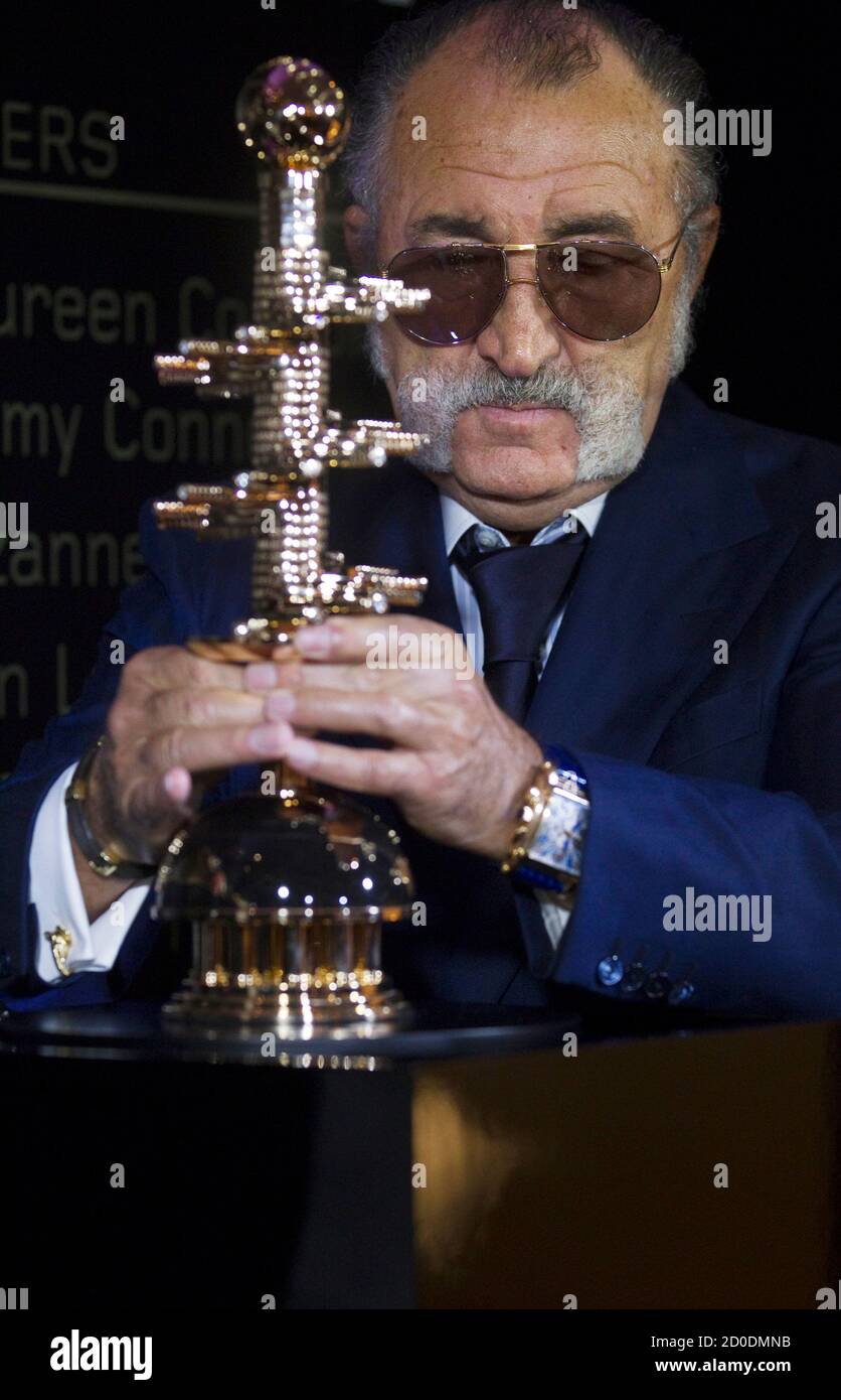 Romanian tennis promoter Ion Tiriac shows a trophy bearing his name during  its presentation in Madrid April 7, 2011. Tiriac believes changes including  bigger, slower balls and blue courts would make the