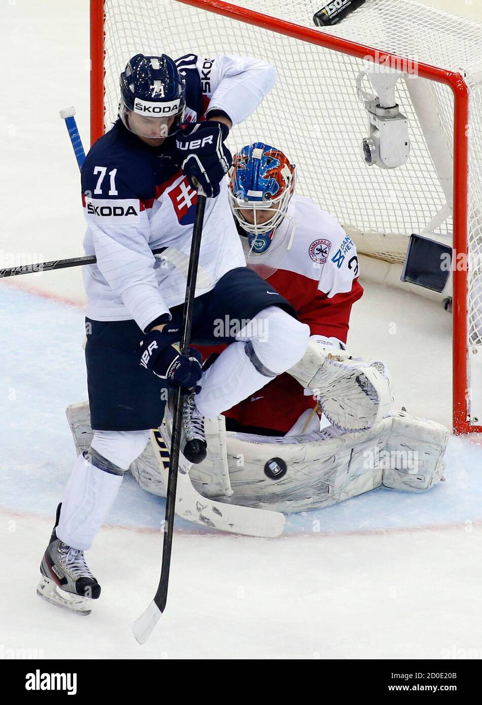 Slovakia's Juraj Mikus (L) challenges Denmark's goalie Simon Nielsen (R)  during the second period of their men's ice hockey World Championship Group  A game against Denmark at Chizhovka Arena in Minsk May