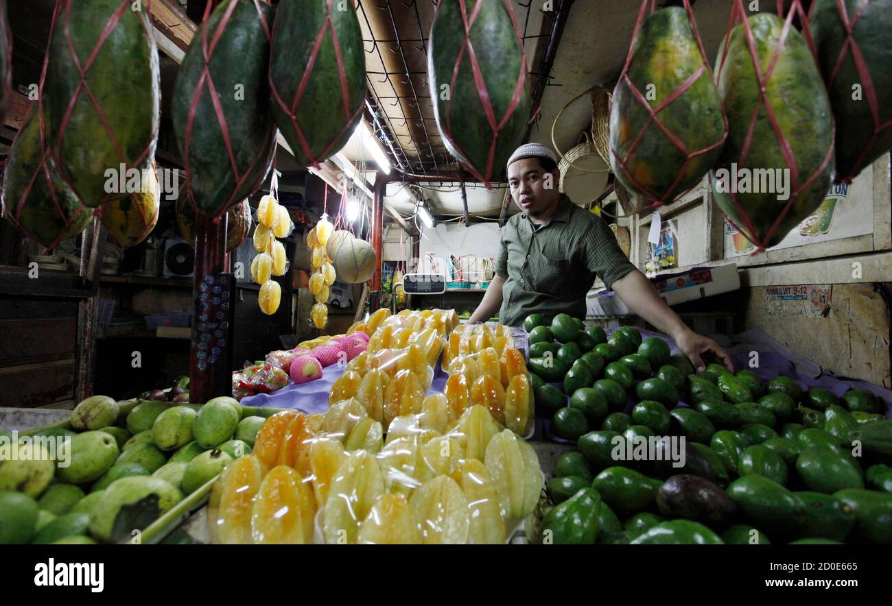 Nata, a fruit vendor, waits for customers at a market in ...