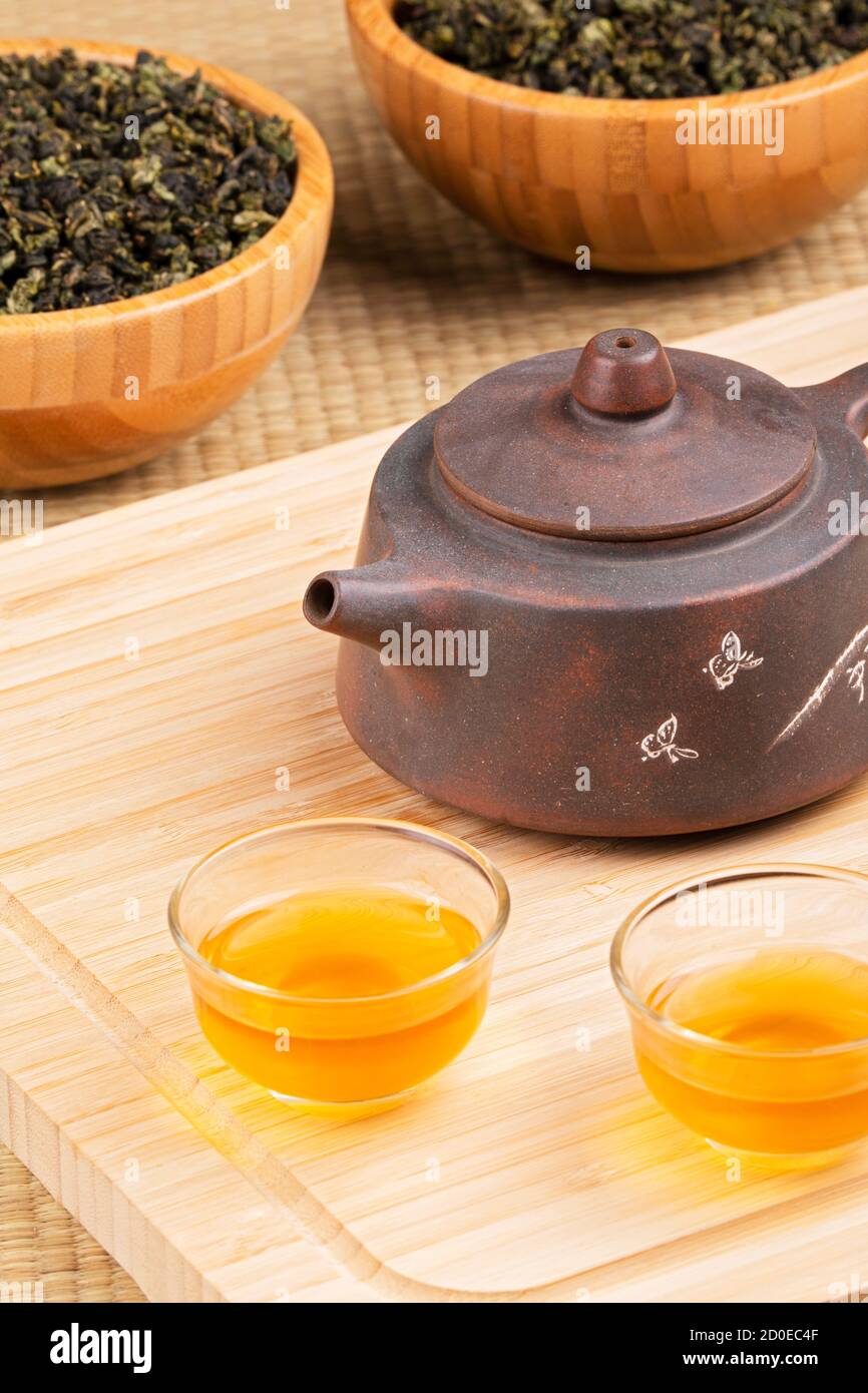 Close up of traditional Chinese tea pot and Green tea isolated on wooden background Stock Photo
