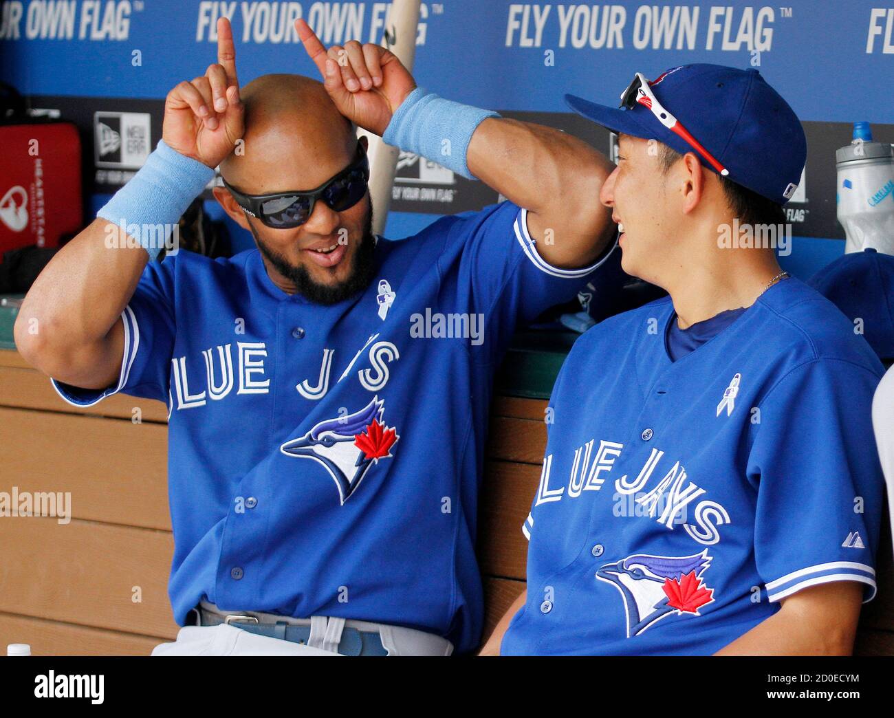 Toronto Blue Jays players Emilio Bonifacio (L) and Munenori Kawasaki (R) share a bit of humour in the dugout prior to the first inning of their MLB American League baseball game against the Texas Rangers in Arlington, Texas, June 16, 2013. REUTERS/Tim Sharp (UNITED STATES - Tags: SPORT BASEBALL) Stock Photo