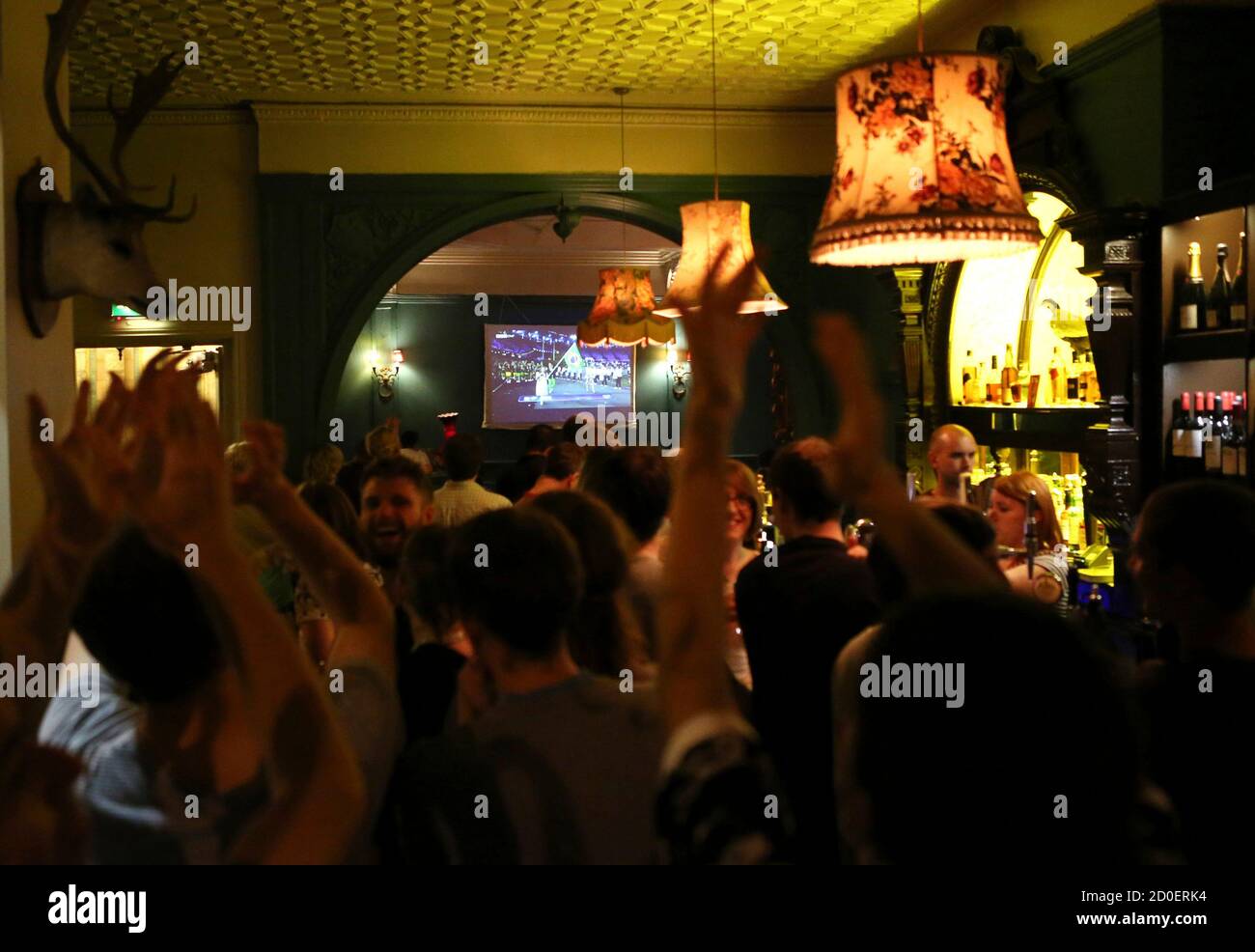 People watch the opening ceremony of the London 2012 Olympic Games at a pub in London July 27, 2012.  REUTERS/Sergio Moraes (BRITAIN - Tags: SPORT OLYMPICS) Stock Photo