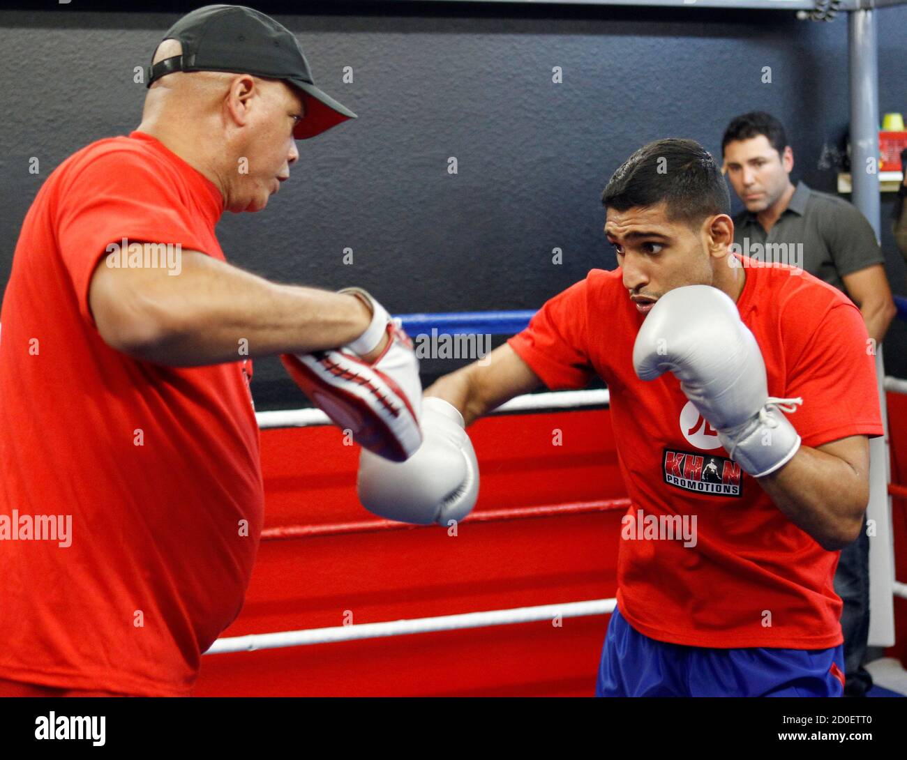 British boxer Amir Khan (R) throws punches with trainer Virgil Hunter (L)  as Golden Boy Promotions President Oscar De La Hoya (rear R) looks on  during a media opportunity at Ponce De