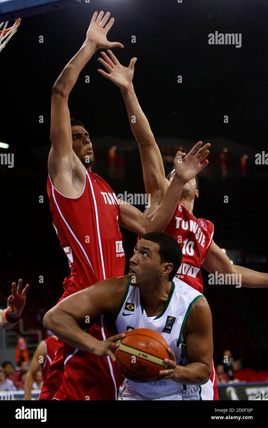 Brazil's Joao Paulo Batista (below) takes aim as Tunisia's Amine Rzig (L) and Atef Maoua defend during their FIBA Basketball World Championship game in Istanbul August 29, 2010.         REUTERS/Murad Sezer (TURKEY  - Tags: SPORT BASKETBALL) Stock Photo