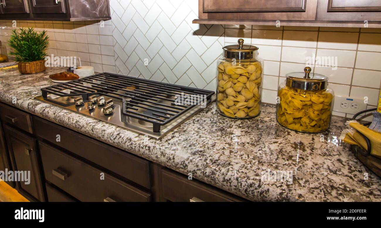 Granite Kitchen Counter With Pasta Jars And Decorator Items Stock Photo
