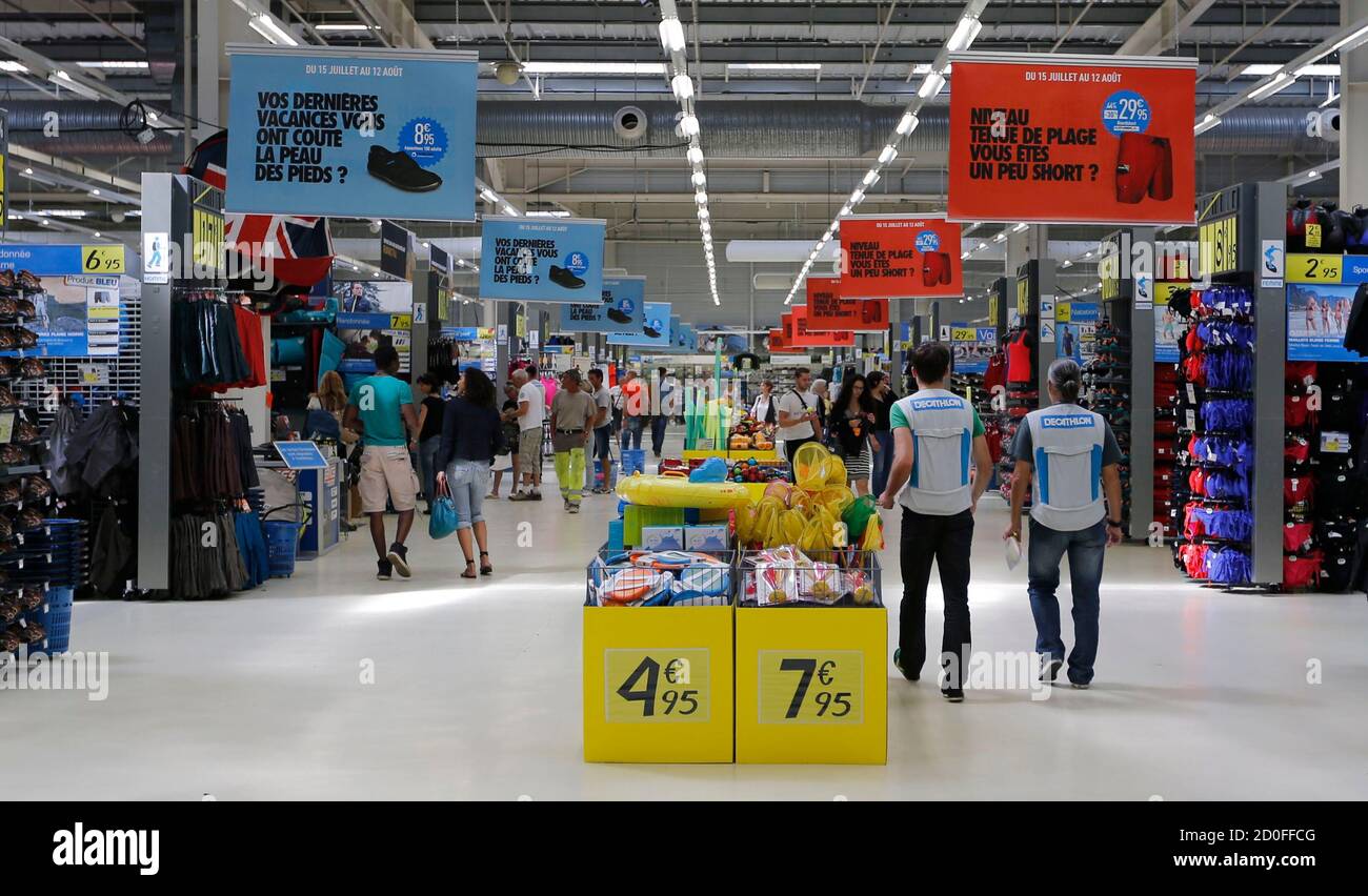 Employees walk in an aisle at the French sports equipment and sportswear  company Decathlon store in Merignac near Bordeaux July 10, 2014. The group,  number one in French distribution of sports equipment,