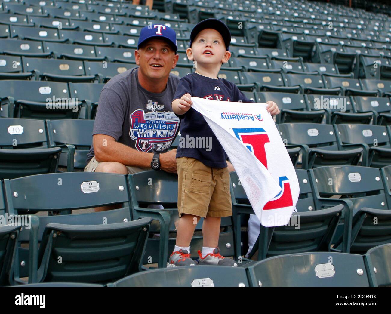 Texas Rangers fans Jake Seymour and his son, W.K. Seymour, 3 years old, await the start of Game 1 of the MLB American League Championship Series baseball playoffs against the Detroit Tigers in Arlington, Texas, October 8, 2011. REUTERS/Danny Moloshok (UNITED STATES  - Tags: SPORT BASEBALL) Stock Photo