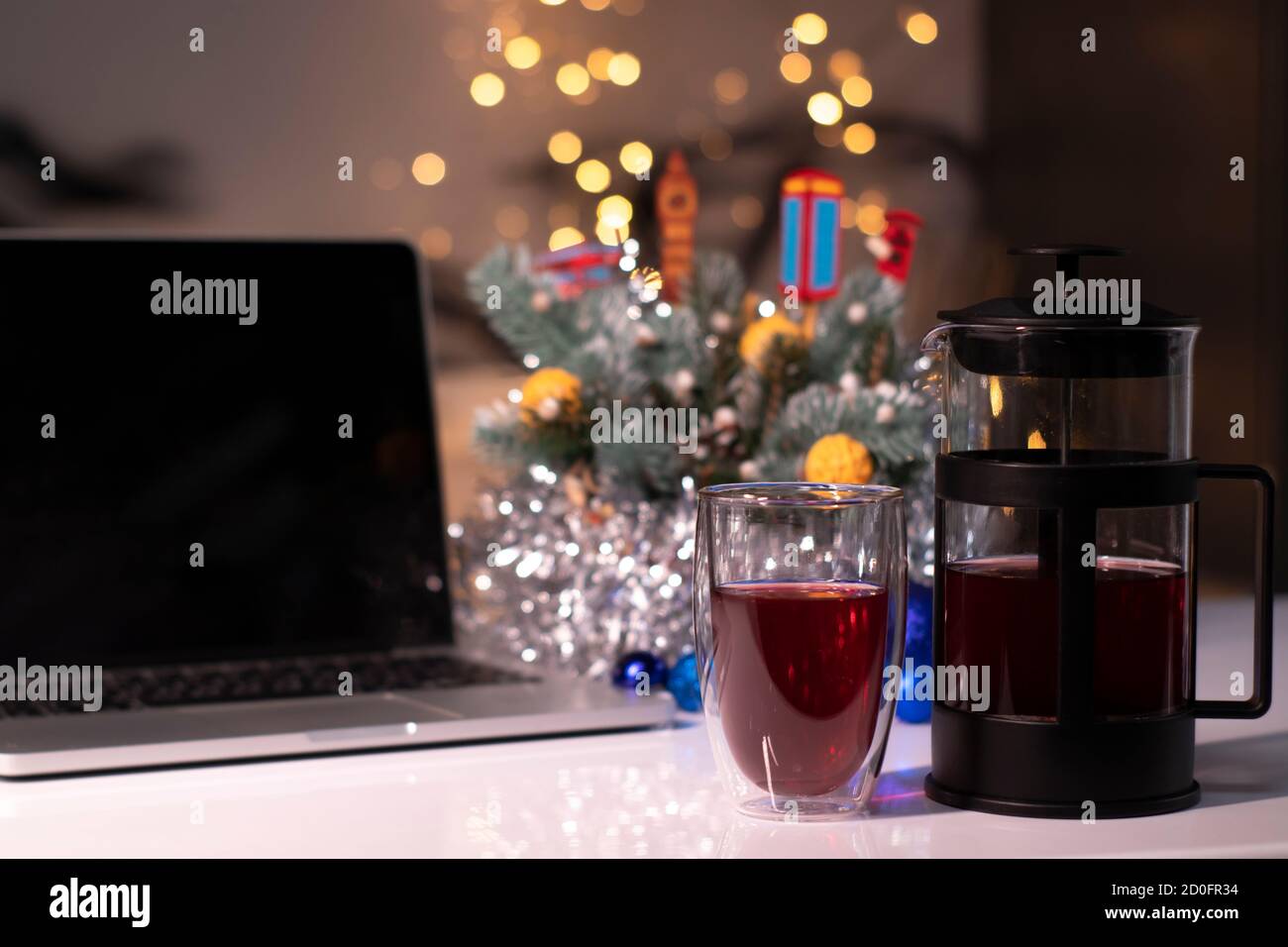 Laptop with black screen next to french press and tea near new years decorations. christmas theme template. Stock Photo