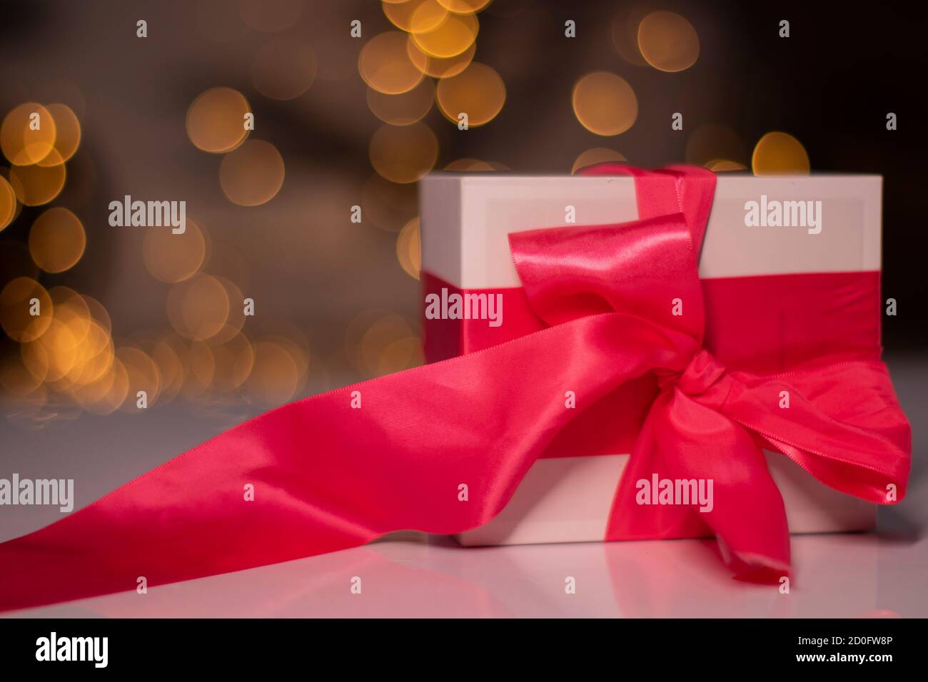 white gift box with pink ribbon bow on gold bokeh background Stock ...