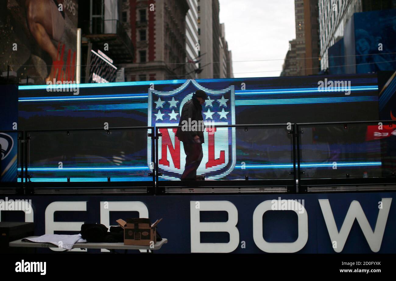 A Worker Walks On A Stage In Front Of The Nfl Logo In New York S Times Square January 27 2014 New Jersey S Metlife Stadium Will Host The First Outdoor Cold Weather Super Bowl
