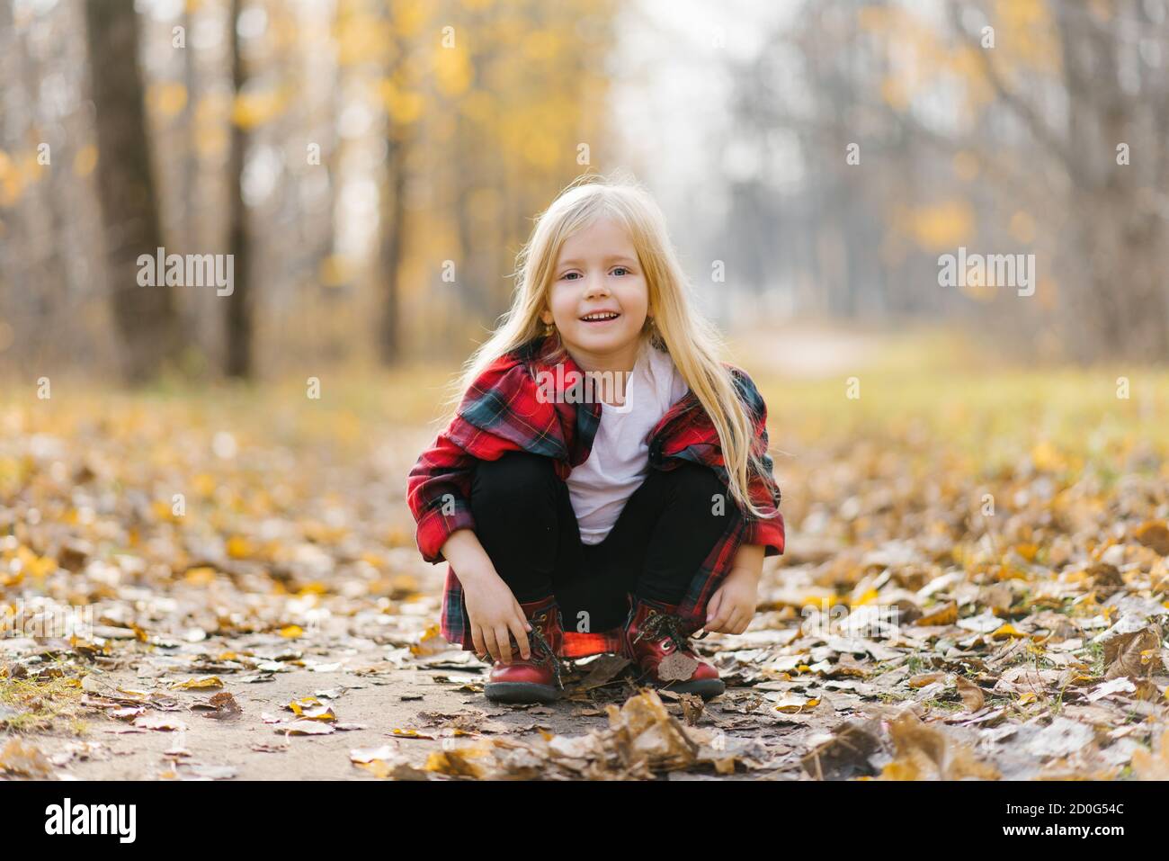 One little girl in the Park. Sunny autumn day in the city Park. Orange-yellow calm mood. Happy childhood Stock Photo