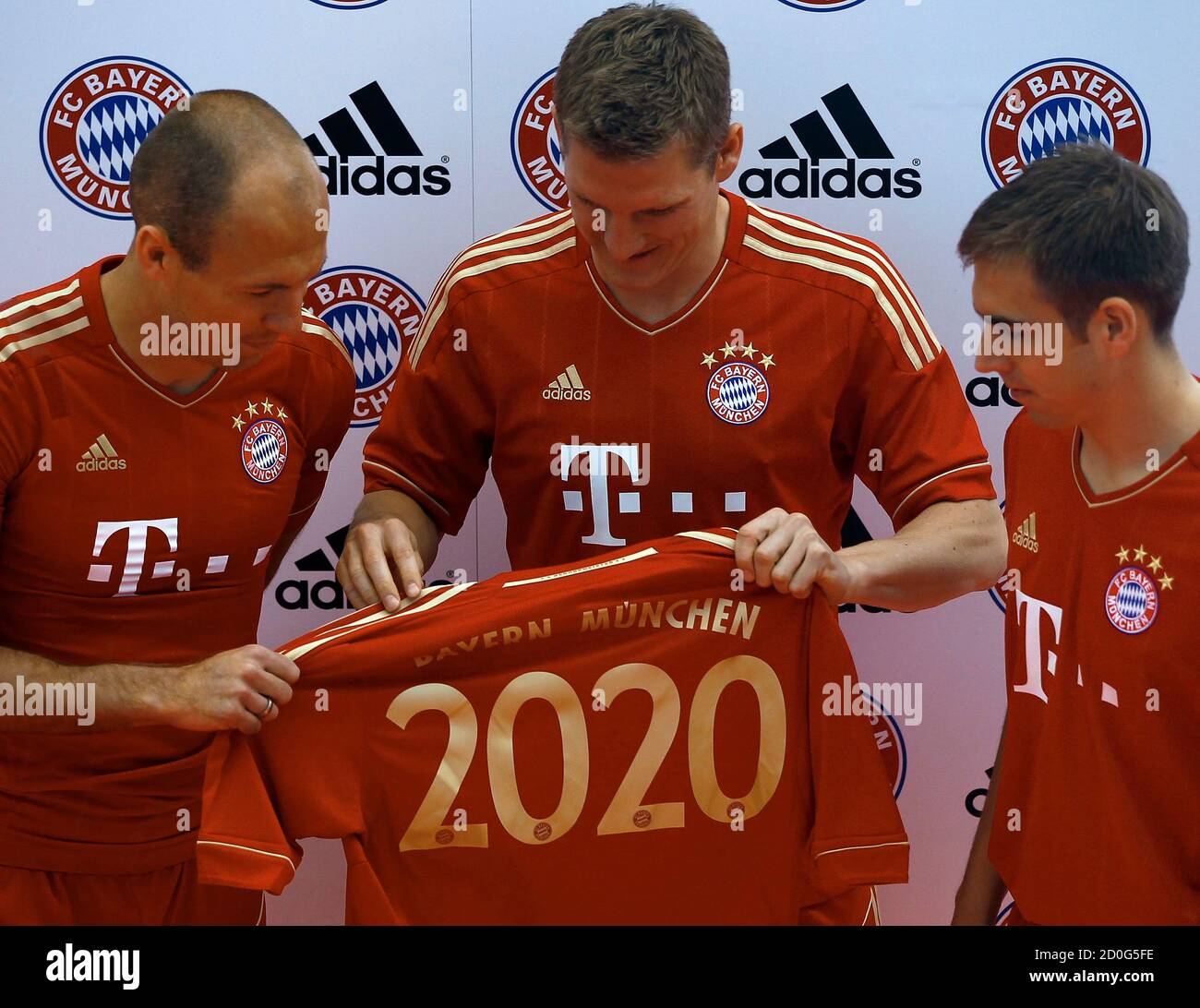 Arjen Robben (L), Philipp Lahm (R) and Bastian Schweisteiger of FC Bayern  Munich present the club's new soccer jersey in Munich April 19, 2011.  Bayern Munich extended its contract with the German