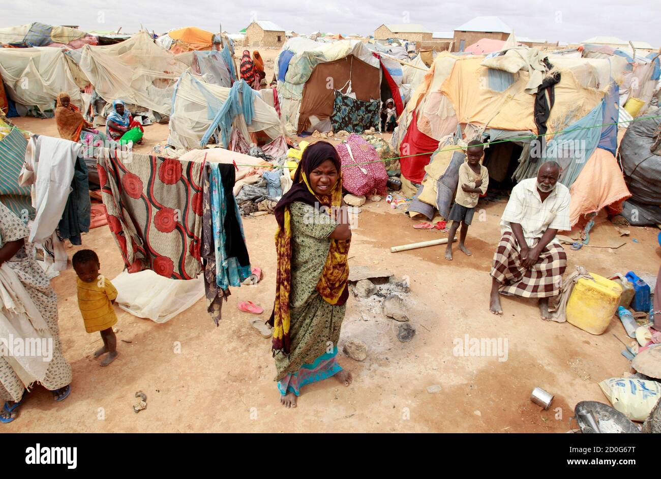 An internally displaced Somali family are seen outside their makeshift shelter at the Hiran IDP settlement in Galkayo, northwest of Somalia's capital Mogadishu, July 18, 2011. Galkayo hosts over 60,000 internally displaced Somalis in 21 settlements and there are always new arrivals due to the prolonged drought. The U.N. has described the drought as an emergency, one level short of a famine. Some 10 million people are affected in the region, dubbed the 'triangle of death' by local media, that straddles Kenya, Somalia and Ethiopia.  REUTERS/Thomas Mukoya (SOMALIA - Tags: SOCIETY CIVIL UNREST ENV Stock Photo