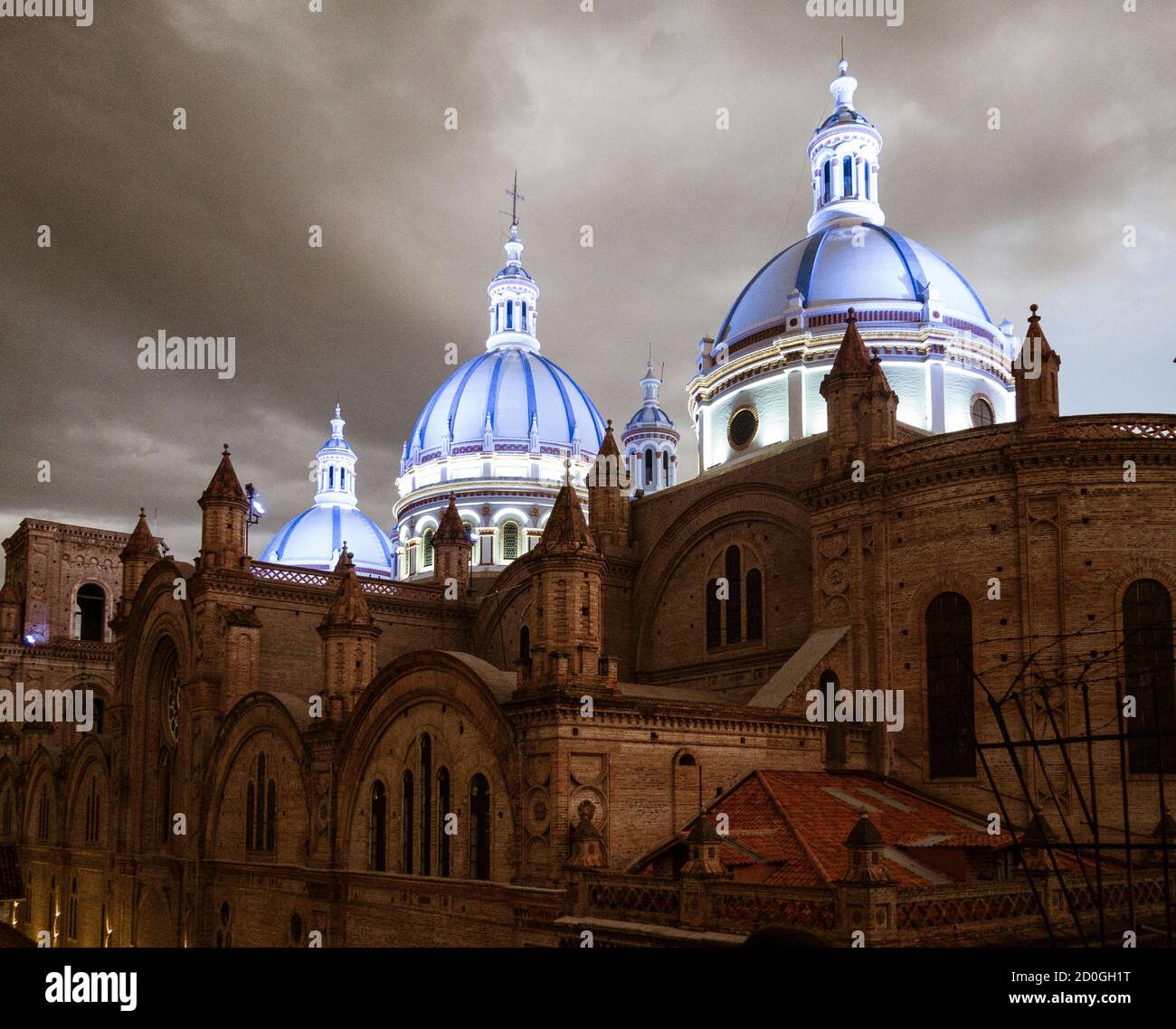 Famous domes of the New Cathedral in Cuenca, Ecuador rise over the city skyline at dusk Stock