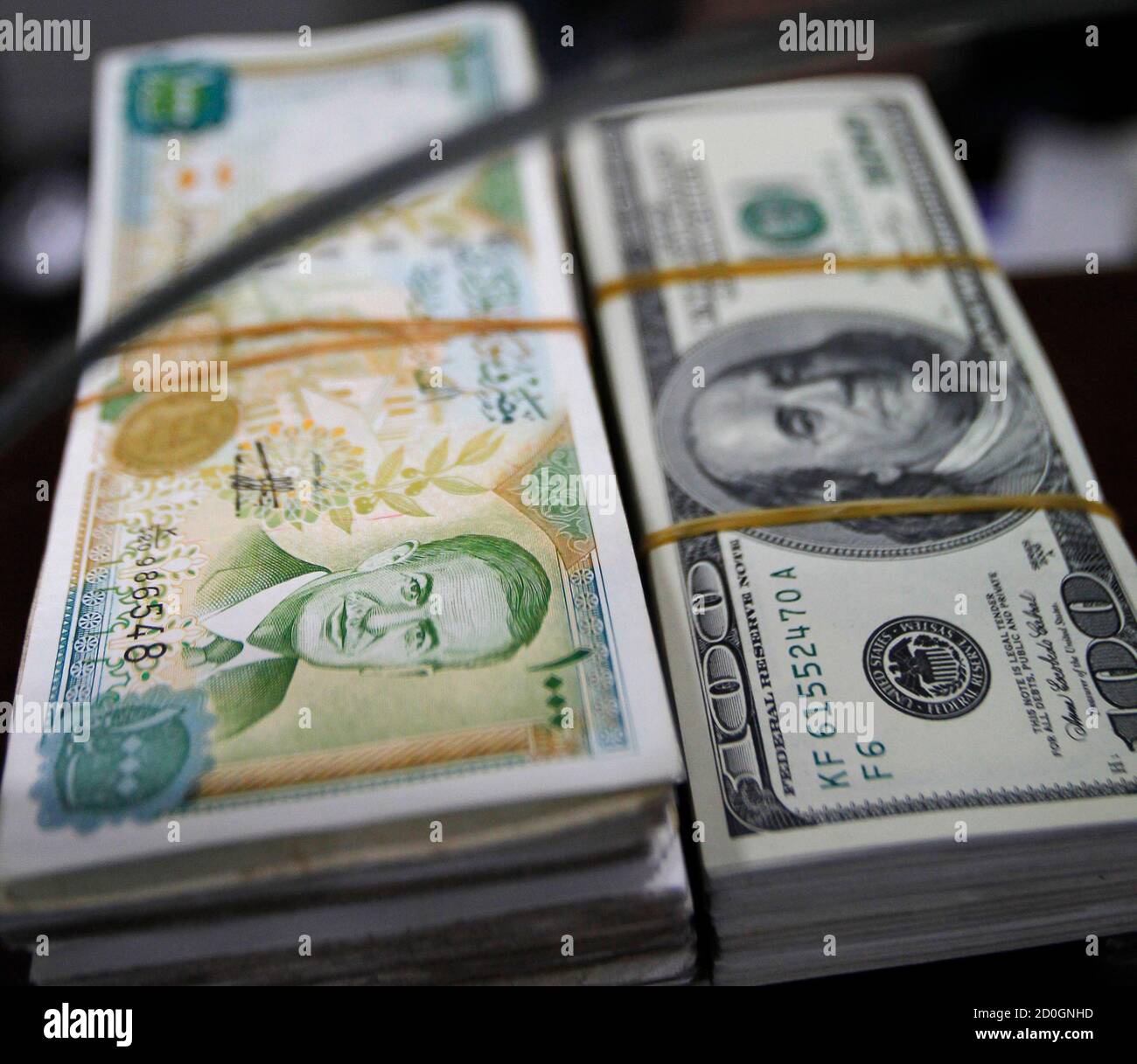 A bundle of Syrian pounds and U.S. dollars is seen in Amman December 6,  2011. Jordanian money changers says on Tuesday demand on the Syrian pound  has plummeted since unprecedented Arab economic