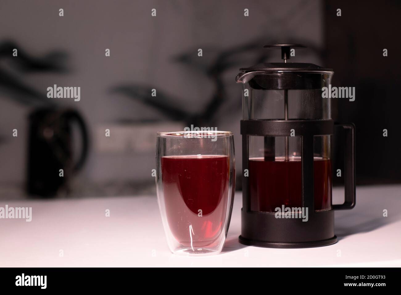 French press and tea in doublebottom glass on white table Stock Photo