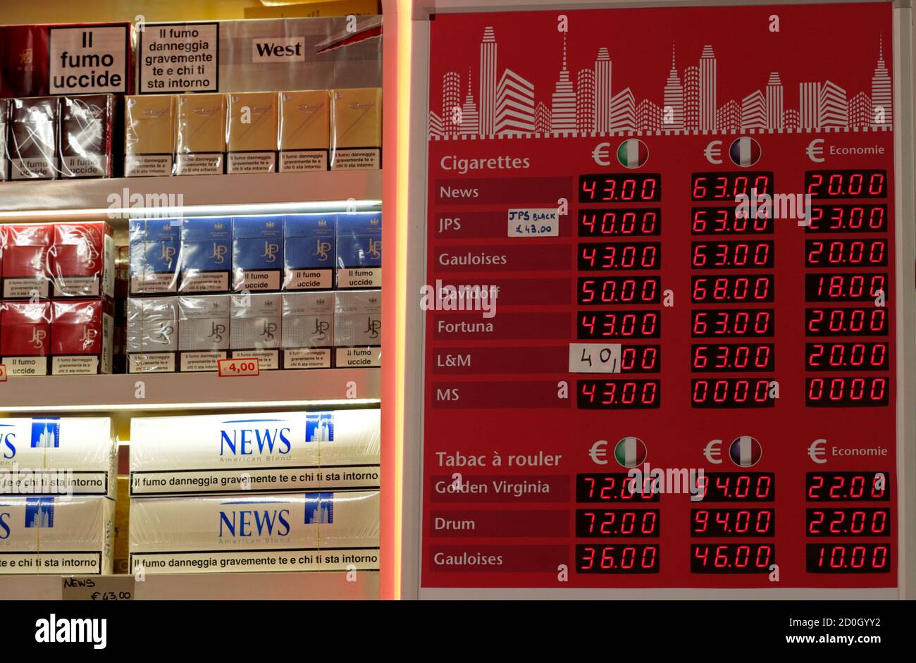 Cigarette packets are seen lined-up next to an information board which displays their price when purchased in Italy (L) and France (C) with the difference in savings (R), in a supermarket in Latte, near the Franco-Italian border, January 13, 2014. The prices of cigarettes have increased by Euro 0.20 on January 13, 2014. REUTERS/Eric Gaillard   (ITALY- Tags: BUSINESS Stock Photo